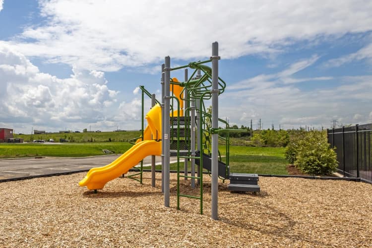 Louisville apartments for rent - image - A playground with a yellow slide and a green climbing structure.